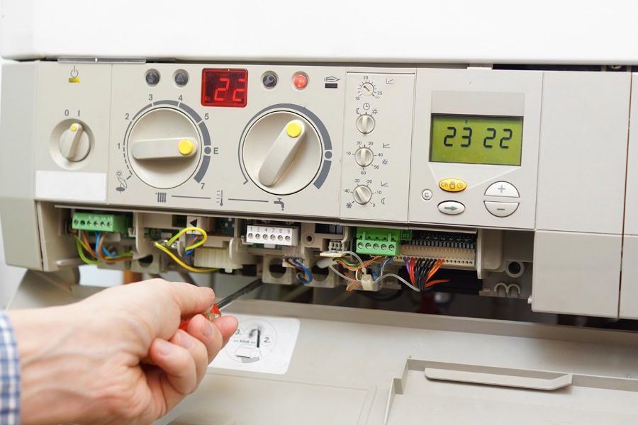 A furnace is being fixed. What to Do When Your Furnace Is Leaking Water.|