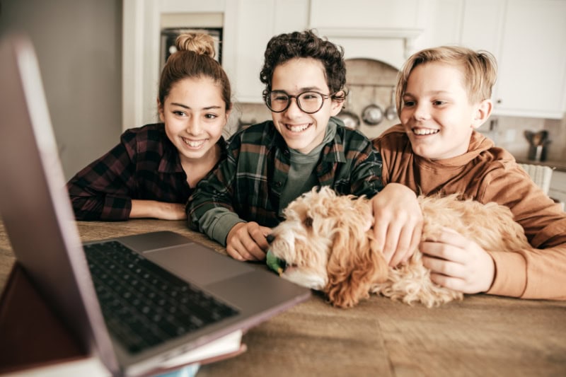 3 Reasons to Consider a Geothermal Heat Pump. Photo of a group of three siblings sitting in their kitchen together.