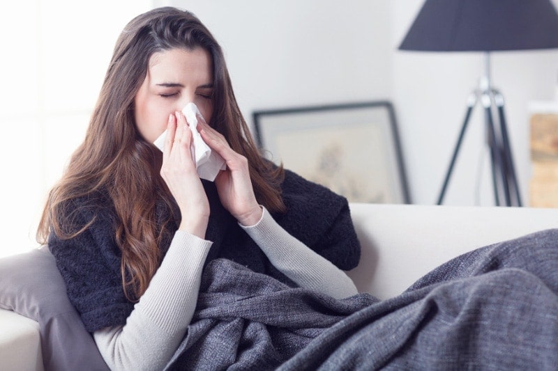 Woman Sneezing on Couch|Woman Sneezing on Couch
