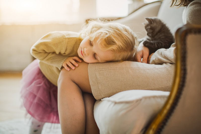 The Basics of Winter Indoor Air Quality. Young girl laying in her moms lap.