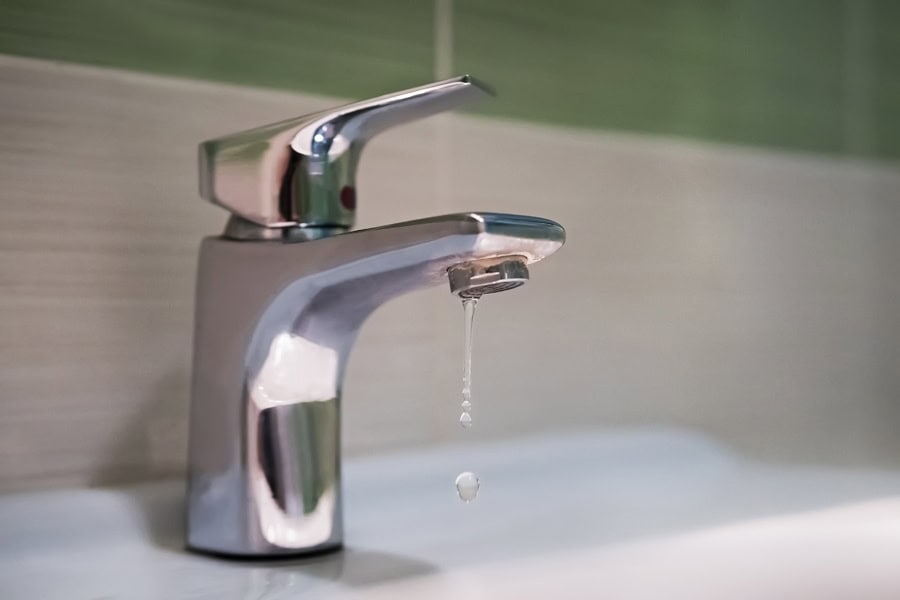 Traditional silver tap dripping. Broken faucet in the tub dripping water. Leaking plumbing. Wasteful water consumption. the concept of saving water.