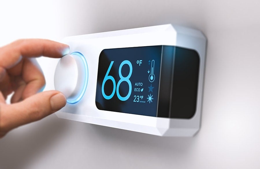 Homeowner's Hand Adjusting the Temperature on a Thermostat